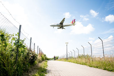 Low angle view of airplane flying against sky