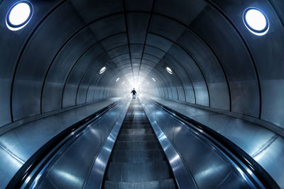 Escalator in illuminated tunnel