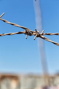 Close-up of barbed wire against clear sky