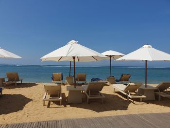 Low angle view of parasol against blue sky