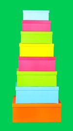 Stack of colorful boxes on green background