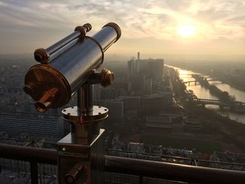 Old telescope and sunset in the city