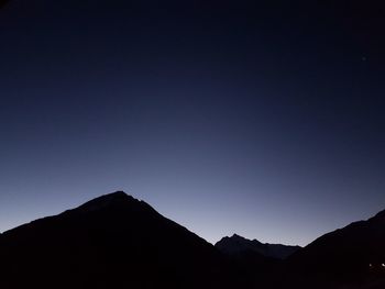 Silhouette mountain against sky at night