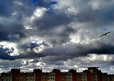 Low angle view of buildings against cloudy sky