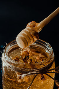 Close-up of drink in glass jar against black background