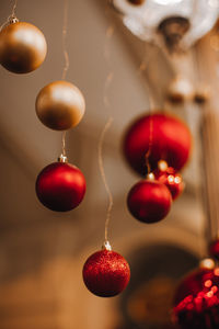 Christmas shiny red and golden balls hanging in the festive interior. new year details andatmosphere