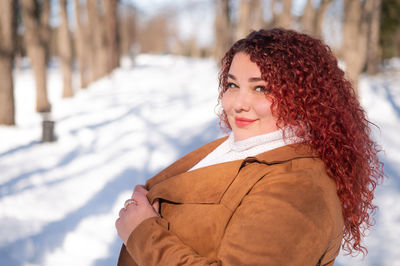 Portrait of young woman standing on snow