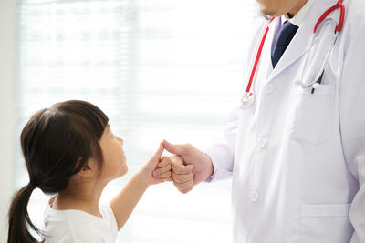Doctor and girl gesturing thumbs up