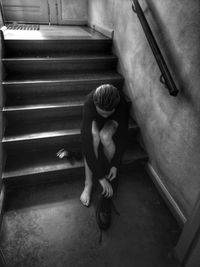 High angle view of girl sitting on staircase