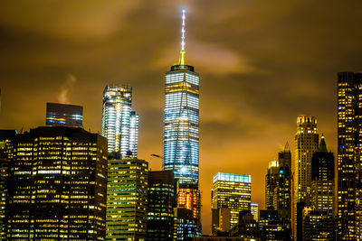 Illuminated buildings in city against sky at night