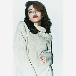 Portrait of young woman standing against white background