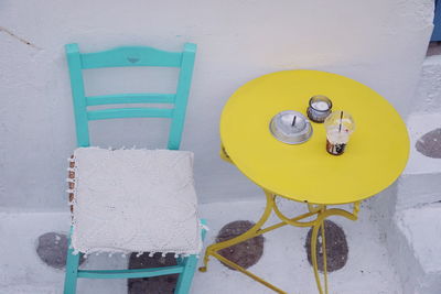 High angle view of empty chair on table against wall