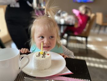 Close-up of young woman holding coffee on table birthday girl 