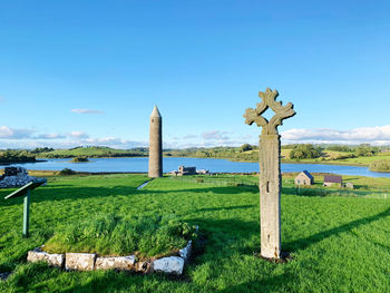Built structure on field against sky, ancient ireland, celtic, cross, round tower, mysterious 