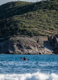 Distant view of person rowing boat in sea