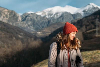 Woman with umbrella standing on mountain during winter