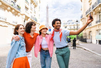 Portrait of smiling friends standing in city