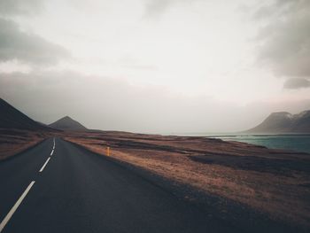 View of road by sea against sky