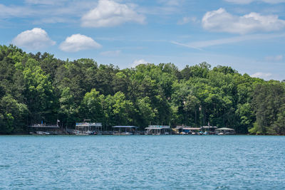 Residential floating docks with a variety of boats moored and covered along the lake shore 