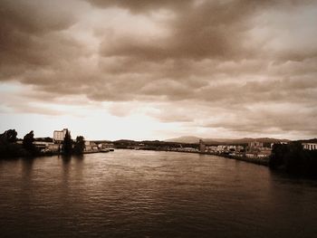 Scenic view of river against cloudy sky during sunset