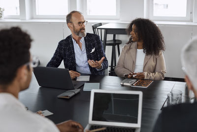 Coworkers talking during business meeting