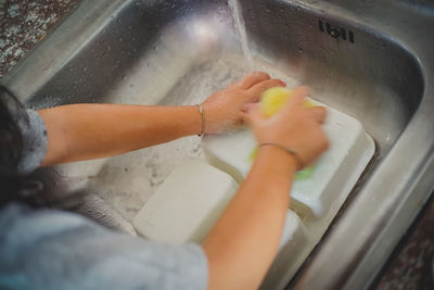 Close-up of woman cleaning plate at home