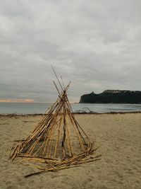 Fishing net on beach against sky