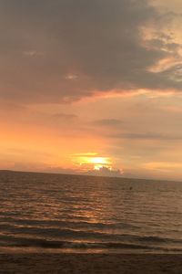 Scenic view of sea against dramatic sky during sunset