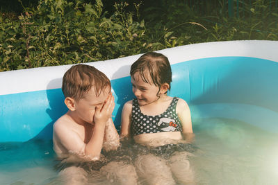 Cheerful happy children in the pool. friends spend summer leisure together on a hot day