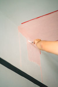 Low angle view of woman painting wall in home