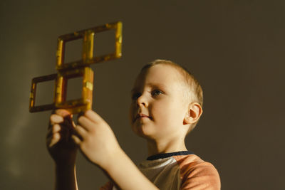 Boy holding magnetic tiles in hand