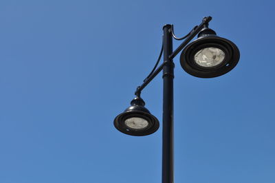 Low angle view of street light against clear blue sky