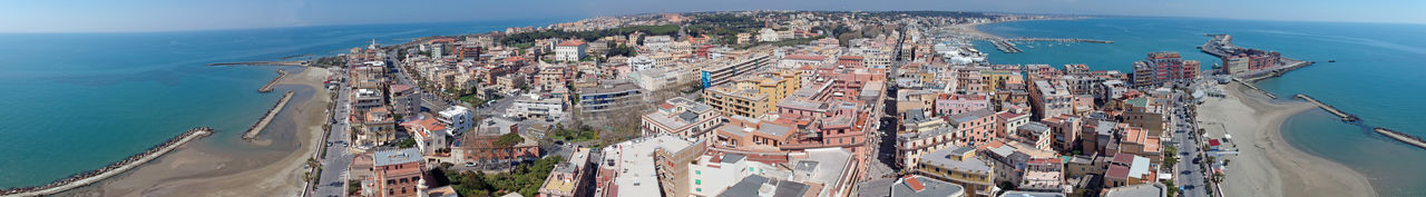 High angle view of buildings by sea against sky