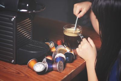 Midsection of woman holding coffee cup on table