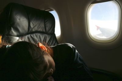 Close-up of man seen through airplane window