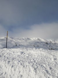 Snow covered field against sky