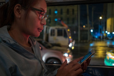 Young woman using mobile phone at night