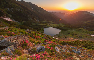 Scenic view of lake by mountains against sky during sunset in rodnei mountains 