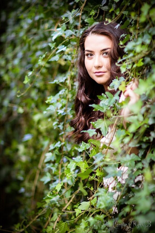 YOUNG WOMAN SITTING ON GRASS