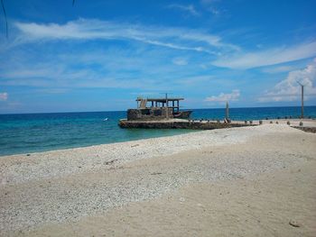 Lifeguard hut on beach against blue sky