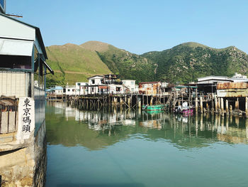 Scenic view of lake by buildings against sky