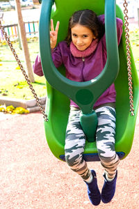 Portrait of smiling girl swinging in playground