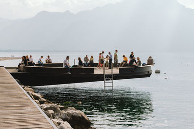 Group of people on beach against mountain range