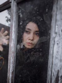 Portrait of woman looking through window