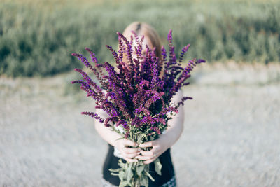 Close-up of woman hand holding purple flower