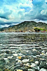 Scenic view of river and mountains against cloudy sky