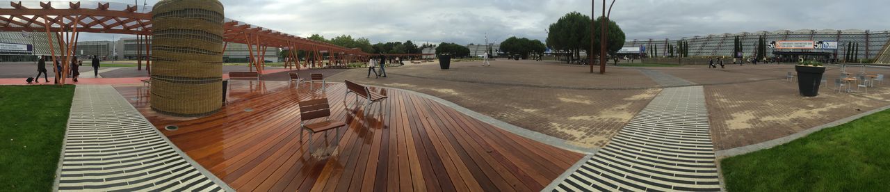 sky, building exterior, built structure, architecture, cloud - sky, incidental people, the way forward, sand, beach, shadow, day, grass, cloud, sunlight, outdoors, large group of people, diminishing perspective, in a row, person