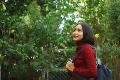 Smiling teenage girl against trees in forest