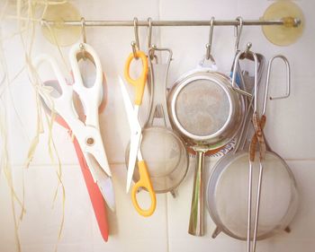 Close-up of kitchen utensils hanging against wall at home