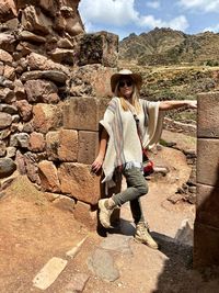 Full length portrait of young woman on rock